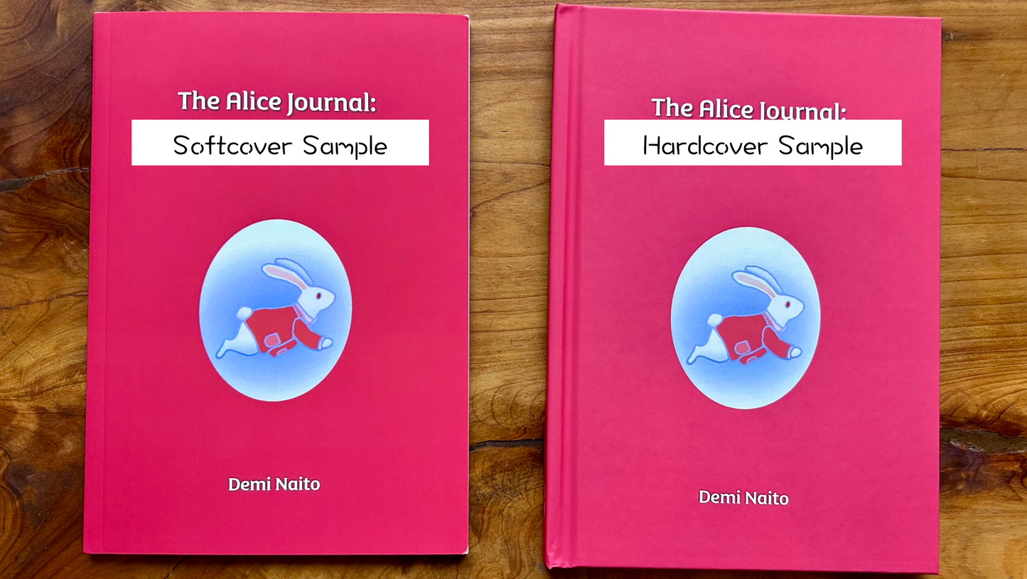 Two 'The Alice Journal' books, one softcover and one hardcover, on a wooden surface.