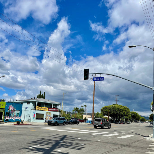 A traffic sign of Alice St. against blue sky with clouds 