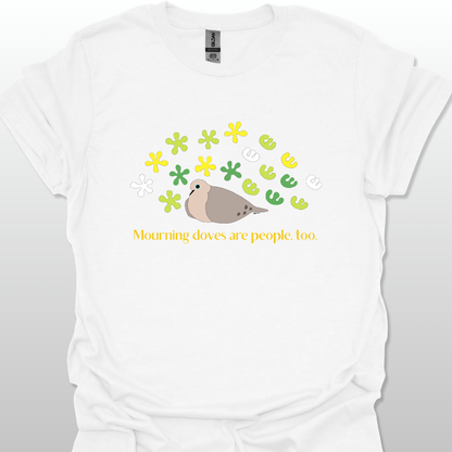 White t-shirt with a graphic of a dove and flowers, text 'Mourning doves are people too.' on a white background