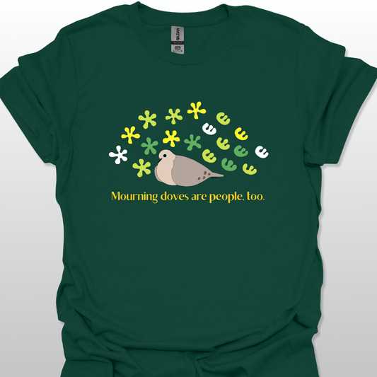 Forest green t-shirt with a graphic of a dove and flowers, text 'Mourning doves are people, too.'
