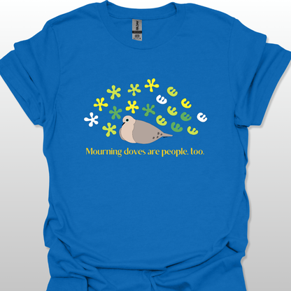 Blue t-shirt with a graphic of a dove and flowers, text 'Mourning doves are people too.' on a white background