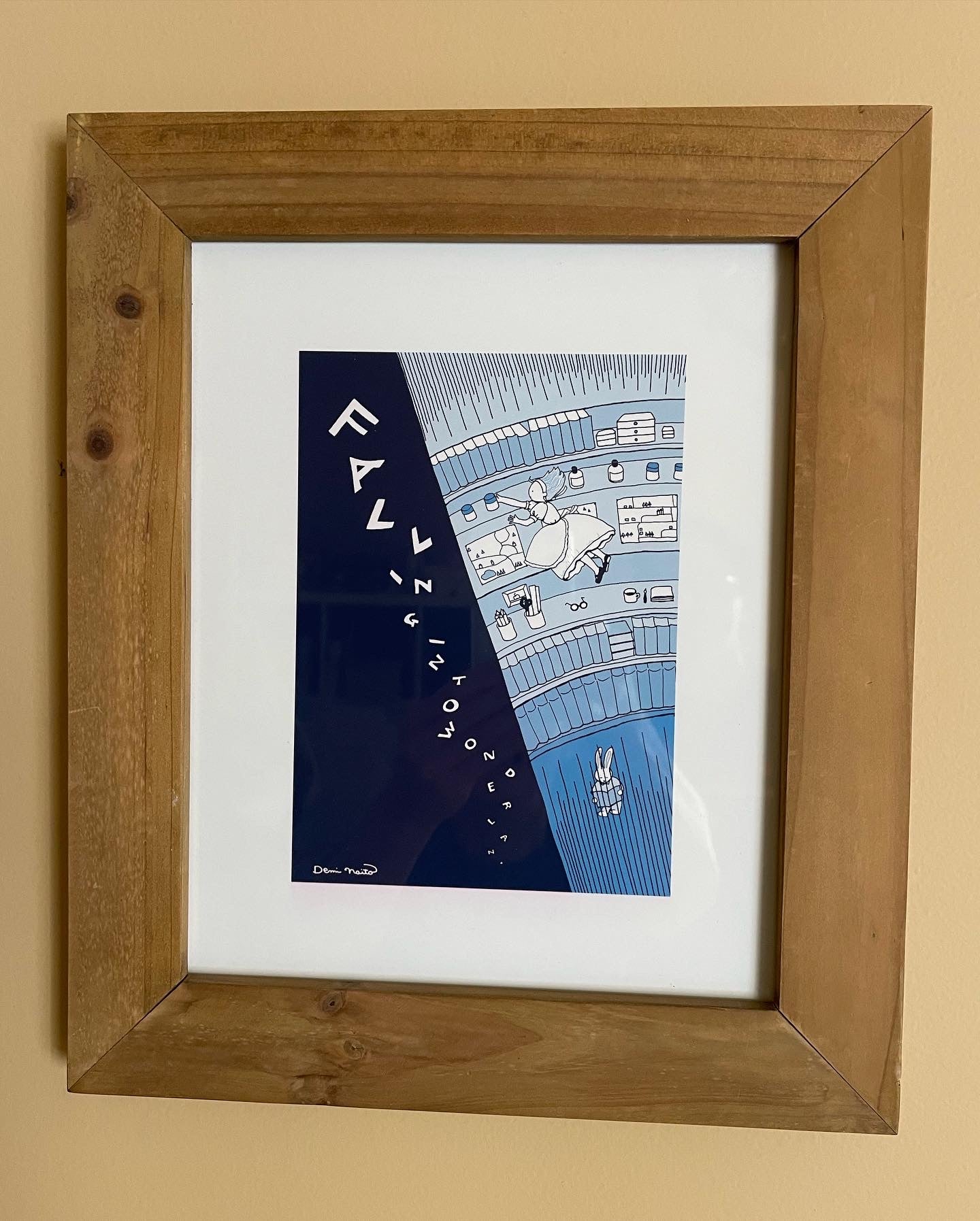 Framed version of Falling Into Wonderland print with a scene of Alice falling into a well after the white rabbit.