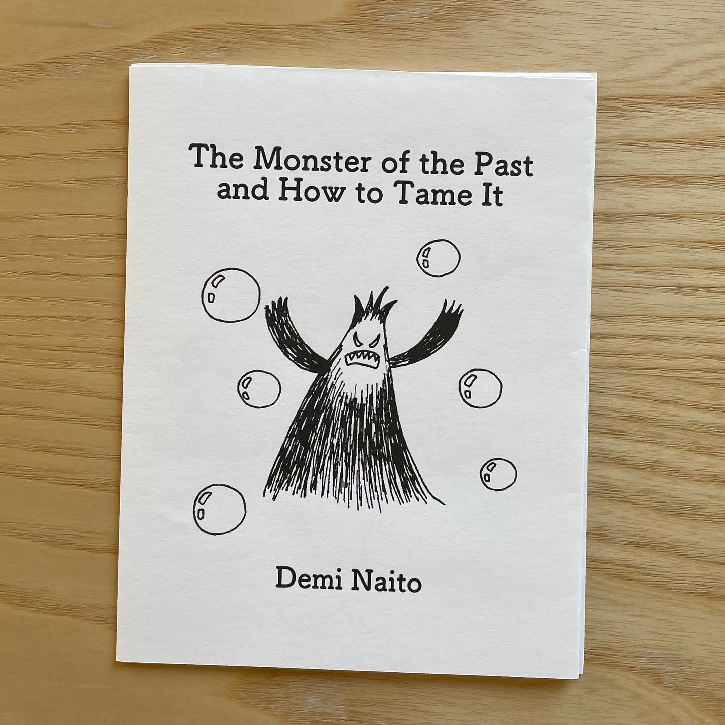 Cover of 'The Monster of the Past and How to Tame It' Zine by Demi Naito with b&w illustration of cute, scary monster.