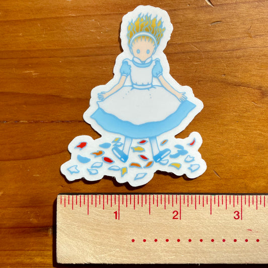 Sticker of Alice landing on a wooden surface with a ruler for scale.