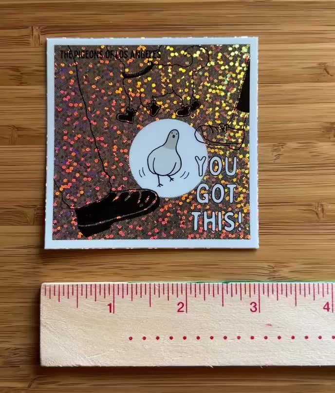 Video of square sticker with a comic pigeon avoiding feet and 'You Got This' text on a glittery, multi-colored background.